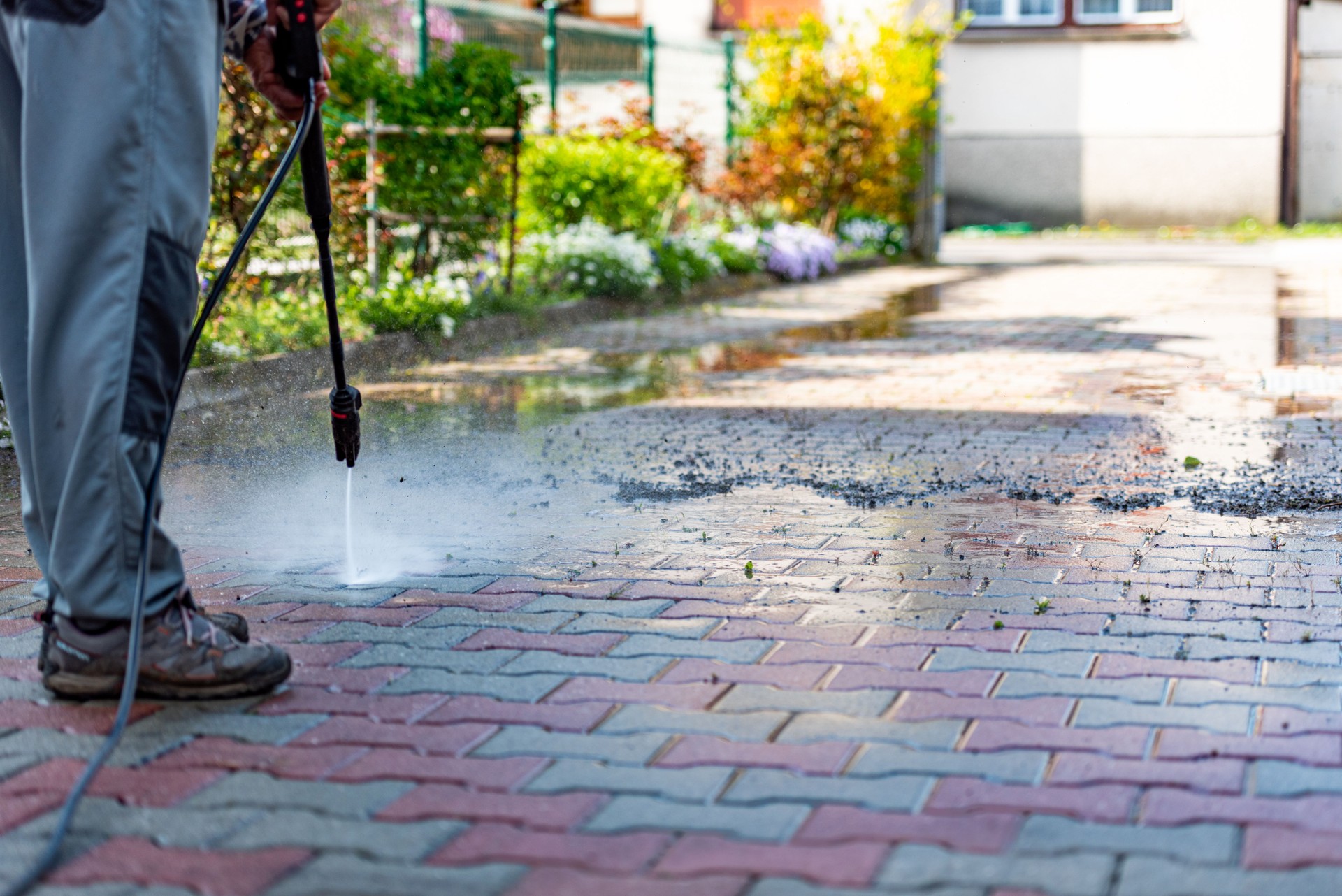 Active Senior Man in Spring Cleaning the Patio Using High Pressure Washer